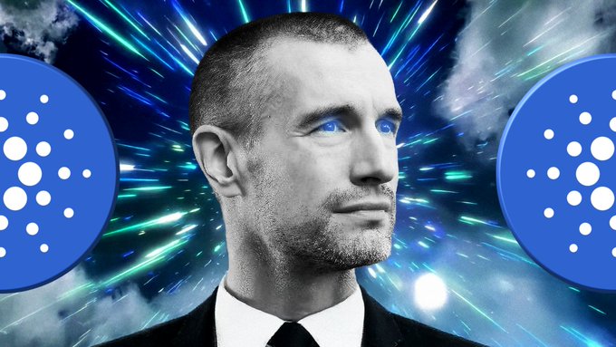 The image features a man wearing a suit and tie with blue dots surrounding him. The background of the image has a blue and green color scheme, and there are two blue circles with white dots in the center. The caption reads "Just In: IOG Director of Software Architecture Nicolas Biri says IOG Software Architect Sebastian Nagel and his team are doing the heavy lifting for #Cardano Ouroboros Leios, 'we'll make it."