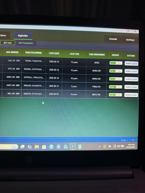 A laptop screen displaying a DigiDollar wallet interface showing ICO Vault transactions, including columns for SDD minted, DGB collateral, lock dates, lock tier, time remaining, and health percentages.