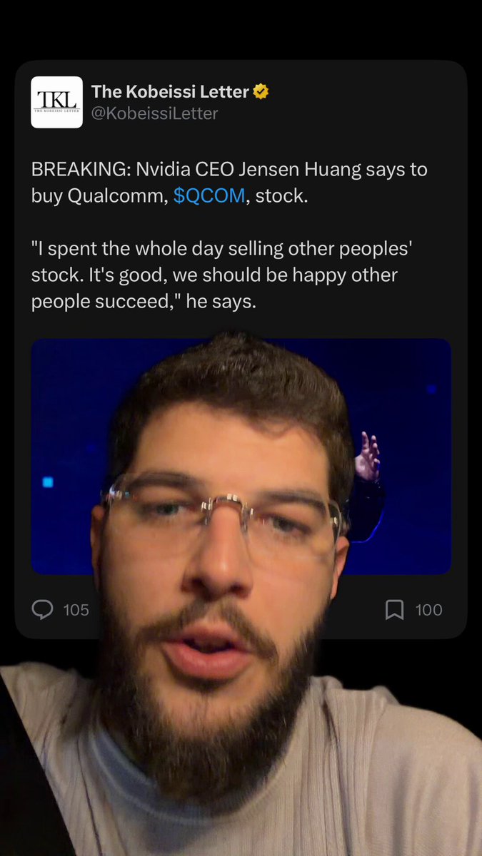 The image shows a man wearing glasses with a beard, who appears to be looking at his phone screen. On the screen of his phone, there are two posts - one containing text that reads "BREAKING: NIVIA CEO JENESEN HUANG SAYS TO BUY QCOM STOCK 50COM STOCK", and another post that says "THE KOBEISSILET THE KOBEISSITLE TLEFT". The man seems to be reading or responding to these posts, possibly discussing the stock market or sharing information about a recent event.