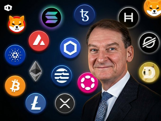 A man in a dark suit and tie stands smiling in front of various cryptocurrency logos including Shiba Inu, Solana, Tezos, Hedera, and Stellar.