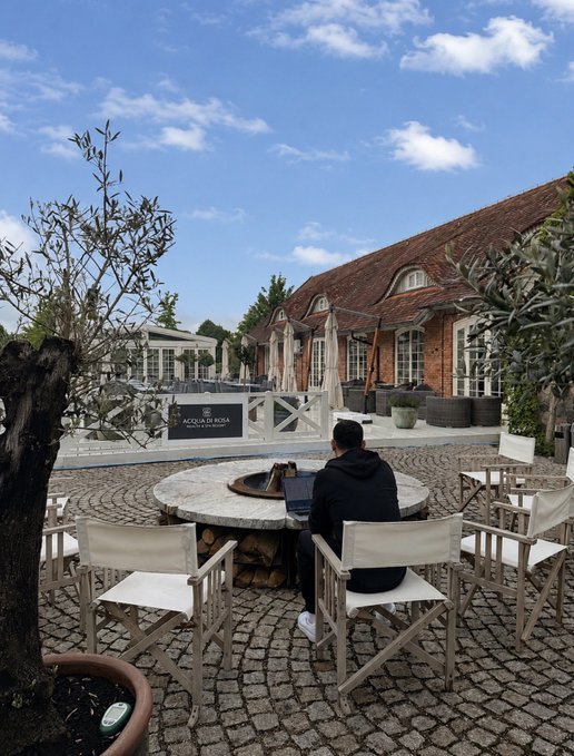 The image shows a man sitting at an outdoor table with chairs, working on his laptop while enjoying the pleasant weather outside. The setting appears to be a patio or courtyard area of a building, possibly a hotel or restaurant, as there are multiple chairs and tables present in the scene. A potted plant is also visible near one of the chairs. The man's focus on his work suggests that he might be taking advantage of the rural long weekend for some leisurely outdoor activities while still being productive.

The post seems to be promoting a vacation or getaway, as it mentions "Work settings for $SPECTRE Rural long weekend". This implies that the location is ideal for those seeking relaxation and productivity during their time off from work. The presence of chairs and tables in the image further supports this idea, as they provide an outdoor workspace where one can comfortably work on a laptop while enjoying the fresh air and natural surroundings.