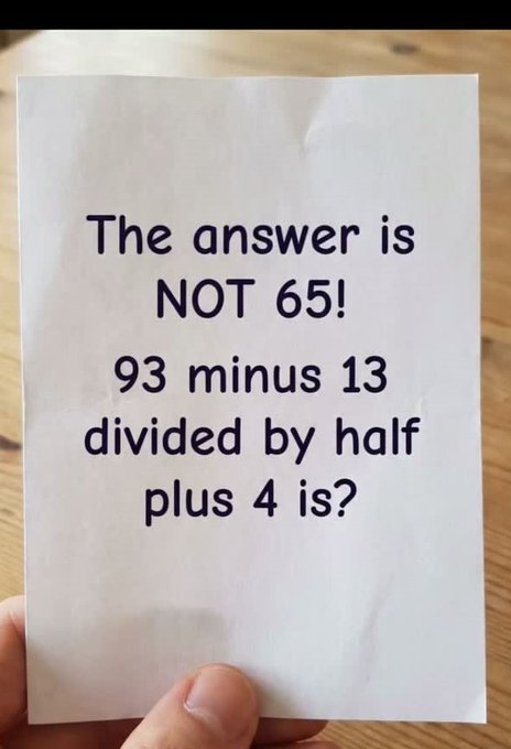 A hand holds a white card displaying the text "The answer is NOT 65! 93 minus 13 divided by half plus 4 is?" The image presents the trick math problem mentioned in the post, challenging viewers to solve it correctly while warning them that 65 is a common wrong answer due to misinterpreting "divided by half."