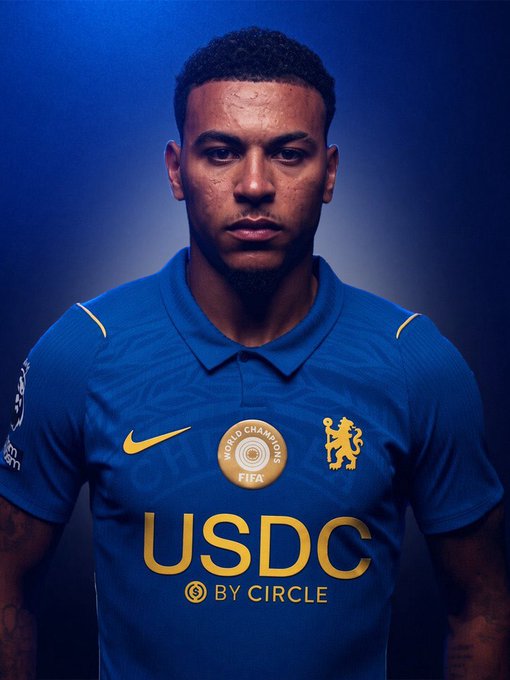 A Chelsea FC player models the team's blue kit featuring prominent "USDC by Circle" sponsorship branding on the front, along with the Nike logo, World Champions FIFA badge, and Chelsea's lion crest. The image showcases how the USDC cryptocurrency sponsorship appears on the Premier League club's official jersey.