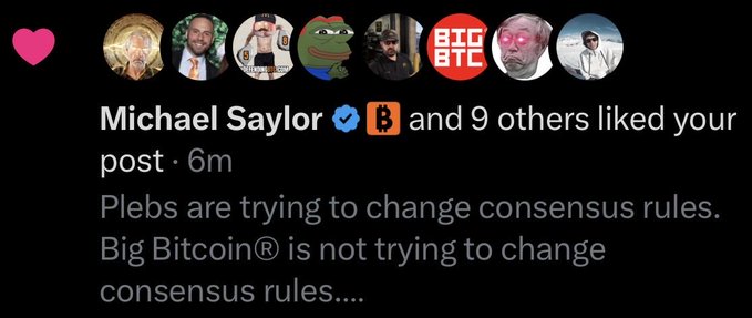 A social media notification shows that Michael Saylor (✓) along with a Bitcoin (₿) account and 9 others liked a post, which reads: "Plebs are trying to change consensus rules. Big Bitcoin® is not trying to change consensus rules..." — confirming that the user's post about "Big Bitcoin®" received a like from the prominent Bitcoin advocate Michael Saylor.