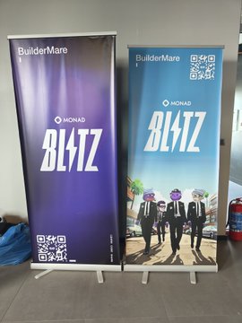 Two vertical banners for "BuilderMare" are displayed on stands, promoting "MONAD BLITZ" with one featuring a QR code and a blue cityscape illustration, fitting the post's "Mekandayız" (We're at the venue) message indicating the event is taking place on-site.