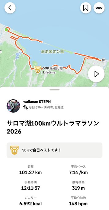 A screenshot of the STEPN app shows a completed 101.27 km Saroma Lake Ultra Marathon 2026, completed in 12:11:57 at a 7:14/km pace by user "walkman STEPN" on 5/04 in Hokkaido, celebrating their first 50K PR. This corresponds to the runner's celebratory post about finishing the ultra marathon just under the time limit and officially becoming "Ultraman."