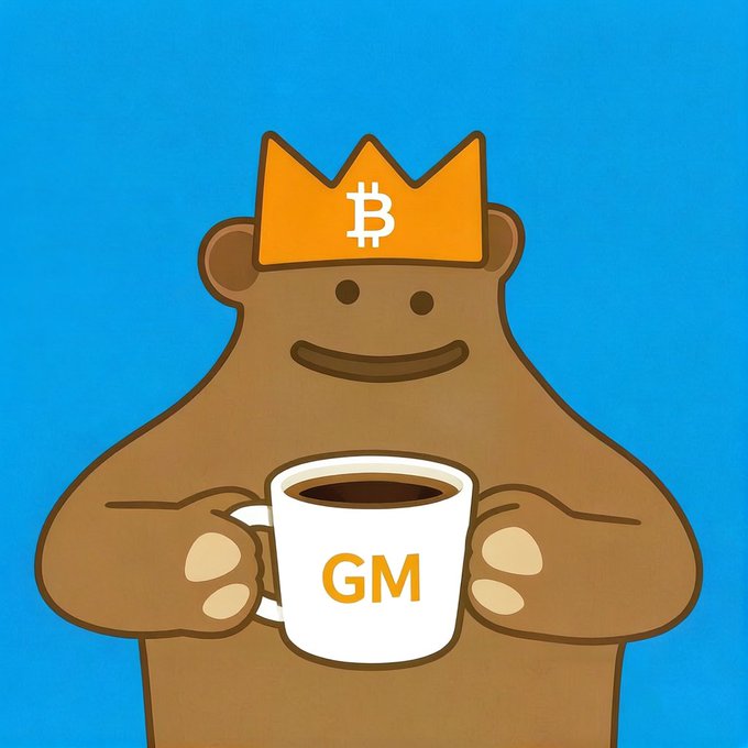 An illustration of a brown bear wearing an orange crown adorned with the Bitcoin 'B' logo, holding a white coffee mug that says 'GM' against a solid blue background.