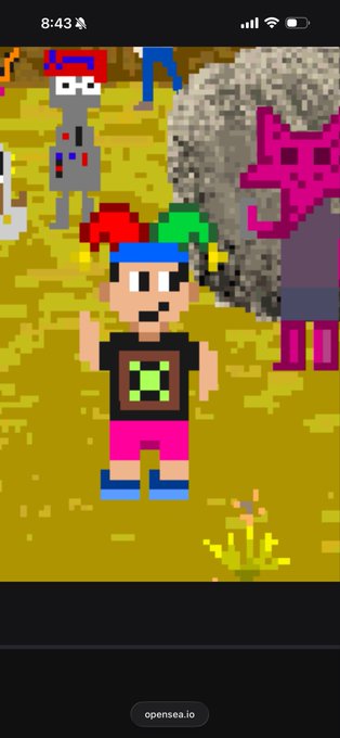 A pixel art character with red and green hair, wearing a black shirt and pink shorts, standing in a grassy field with other pixelated figures and a pink creature in the background.