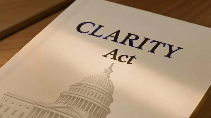 A document titled "CLARITY Act" rests on a wooden surface, featuring an illustration of the U.S. Capitol dome at the bottom. The image directly relates to the post, visually highlighting the legislation that the U.S. Senate has not yet scheduled for consideration.