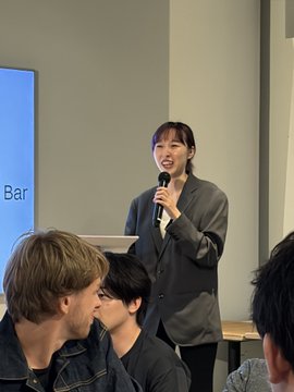 A woman passionately pitches TRUSTAGENT at @easya_app's Pitch Day, held in collaboration with Harvard and MIT, with a screen displaying "Bar" visible in the background.