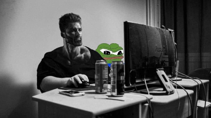 A black-and-white photo shows a man with a Pepe the Frog face superimposed on him, sitting at a desk with energy drinks in front of dual monitors.