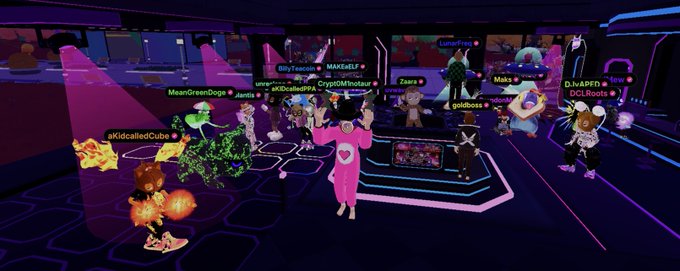 A vibrant virtual world scene featuring various cartoon-style avatars gathered in a neon-lit digital space, with usernames like 'MAITxELF', 'MeanGreenDoqs', 'Jkilla', and 'CryptoMinistap' floating above characters including a pink-suited figure and a flaming dog.