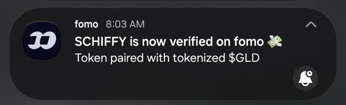 A dark-themed notification alert from fomo at 8:03 AM stating 'SCHIFFY is now verified on fomo 💸 Token paired with tokenized $GLD'.