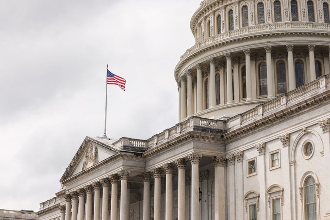The U.S. Capitol dome with the American flag flying overhead, symbolizing the legislative backdrop for the crypto super PAC's new ad campaign in support of the Clarity Act.