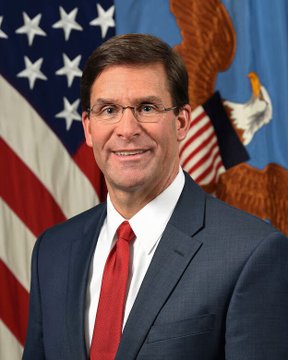 An official portrait of a smiling man in a dark blue suit with a red tie, standing in front of an American flag and the U.S. Department of Defense seal, representing former Secretary of Defense Mark T. Esper as he advocates for the Clarity Act as a national security measure regarding crypto regulation.