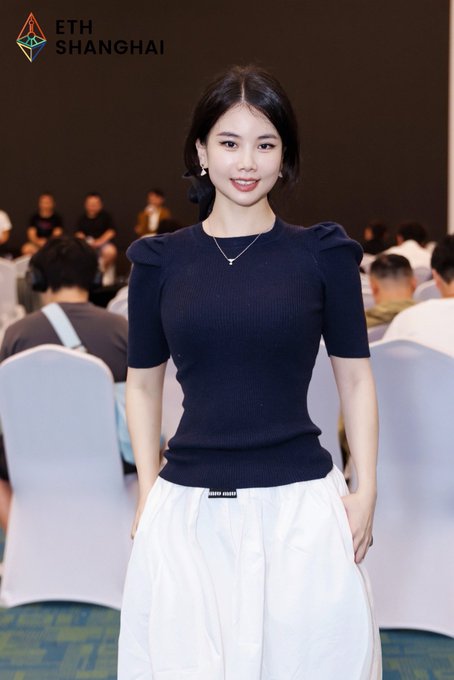 A young woman poses at the ETH Shanghai event, wearing a navy blue puff-sleeve top and a white Miu Miu skirt, with the "ETH SHANGHAI" logo visible in the corner of the image, tying the photo to the conference mentioned in the post.