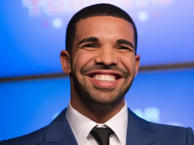 A smiling man in a dark blue suit and black tie stands against a blue background, his joyful expression captured mid-laugh. The image accompanies news of a $1.5 million USDT wager placed on Argentina to defeat Spain in the 2026 FIFA World Cup final, suggesting the man pictured is the high-profile bettor referenced in the post.