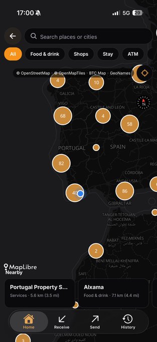 Screenshot of the MapLibre app showing a map of Spain and Portugal with orange numerical markers and a list of nearby places at the bottom.