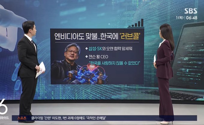 Two news anchors stand before a large screen displaying a Korean news segment about NVIDIA matching with '러브콜' (love call), featuring a photo of Jensen Huang and text in Korean.