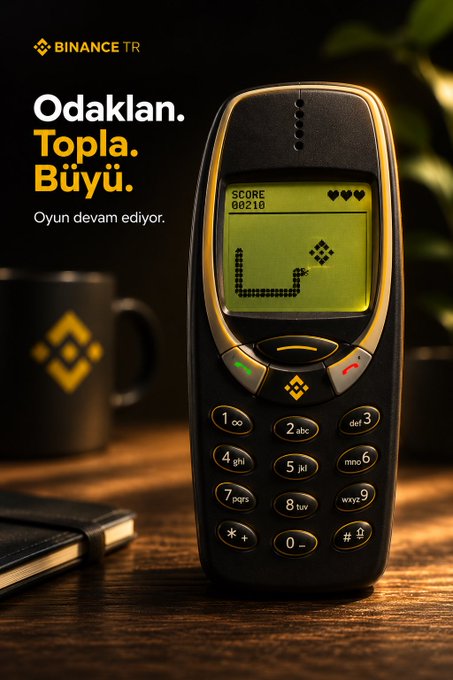 This image features a vintage mobile phone playing the classic Snake game, with the "BINANCE TR" logo visible, suggesting a connection between nostalgic gaming and cryptocurrency. The text "Odaklan. Topla. Büyü." translates to "Focus. Collect. Grow," aligning with the post's theme of merging nostalgia with crypto.