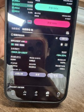 The image shows a person holding a cell phone displaying a screen filled with information about Bitcoin trading. The phone's display features various details such as the current price of Bitcoin, the number of Bitcoins being bought or sold, and other relevant data. The text on the screen is in Chinese, which suggests that this might be an Asian market for Bitcoin trading. The person holding the cell phone appears to be interested in investing in Bitcoin or has just made a trade.