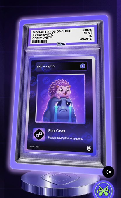 A digital trading card display showing a Monad Cards Onchain NFT (#1039, Wave C) for akbacrypto community, featuring a sad crying blue character with a small lion cub on its head, labeled 'Real Ones - People playing the long game.'