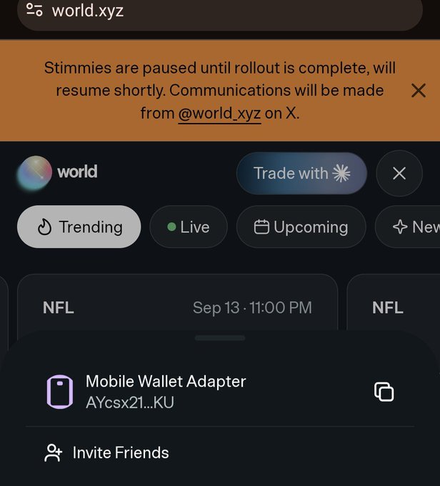 A mobile app screenshot for world.xyz displaying an orange banner stating 'Stimmies are paused until rollout is complete, will resume shortly. Communications will be made from @world.xyz on X.', with a Mobile Wallet Adapter option visible at the bottom.