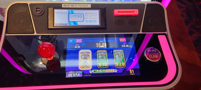 An arcade gambling machine displays a slot-style game with a $10 and $20 bonus ticket offer, showing "MUST BE 21 TO PLAY" at the top and a $0.00 balance, with a red joystick on the left and a "CLAW" button on the right. The image's connection to the "Julian Tomorrow #XRP" post is unclear, as the photo shows a casino-style gaming kiosk rather than anything related to cryptocurrency or XRP.