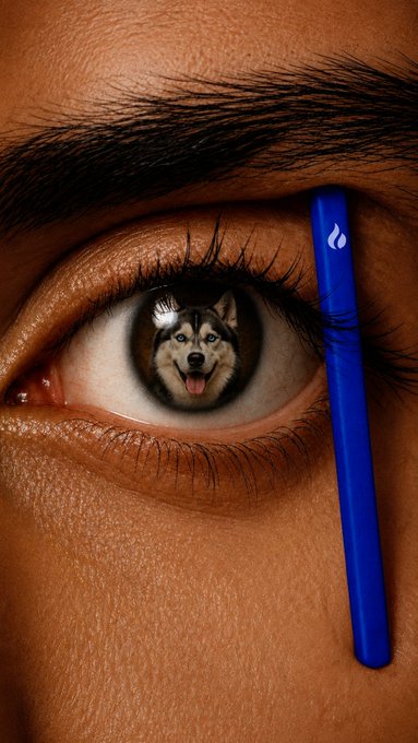 A surreal close-up of a human eye with a husky dog's face reflected in the iris, alongside a blue pen or tool with a flame logo.
