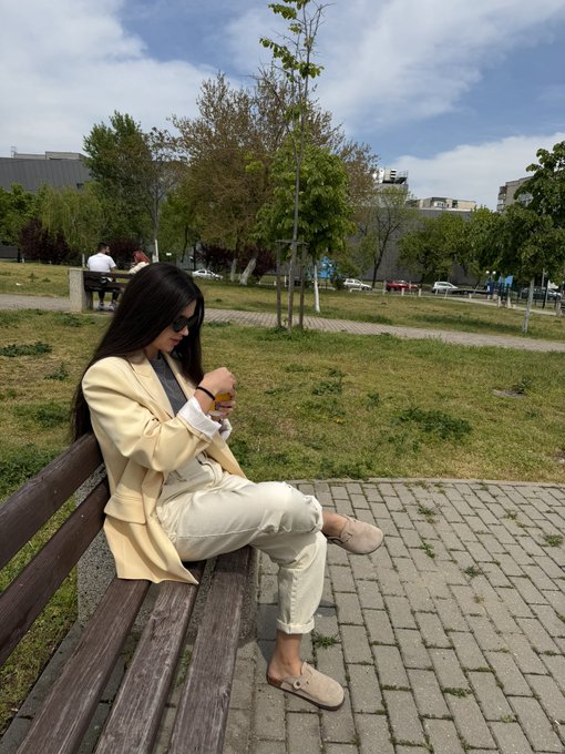 The image shows a woman sitting on a wooden bench with her legs crossed while looking at her phone. The photo has been edited to include text that reads "5 years ago $1000 could’ve turned into: Nike → $330 Ubisoft → $80 GoPro → $90Vs $Bitcoin → $2,100 We all missed the moon sometimes Drop your biggest investing regret or biggest win". This alteration suggests a connection between the woman's actions in the image and an event that occurred 5 years ago.
The edited photo is related to the original post because it includes text from the original post about the woman sitting on a bench with her legs crossed, looking at her phone. The edited version of the photo adds context to the scene by incorporating elements from the original post's description.