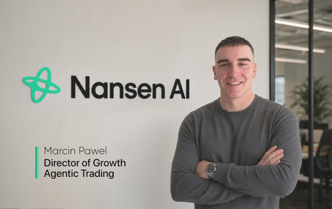 "Marvin Pawel stands confidently beside a large sign displaying 'Nansen Al' in green letters at an office building. The company has created an advanced AI platform specifically designed for onchain investors, assets, and financial traders. Marvin has already joined Nansen as a Director of Growth and is excited to continue his journey with the AI platform."
