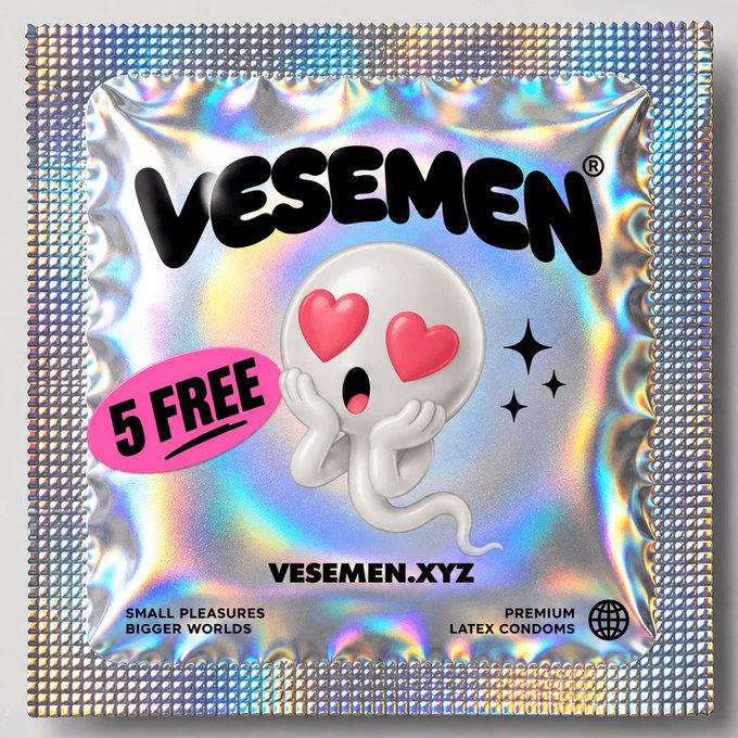 A holographic silver package of 'VESEMEN' premium latex condoms featuring a ghost character with heart-shaped eyes. The packaging includes a pink '5 FREE' badge, the website 'VESEMEN.XYZ', and the tagline 'SMALL PLEASURES BIGGER WORLDS'.
