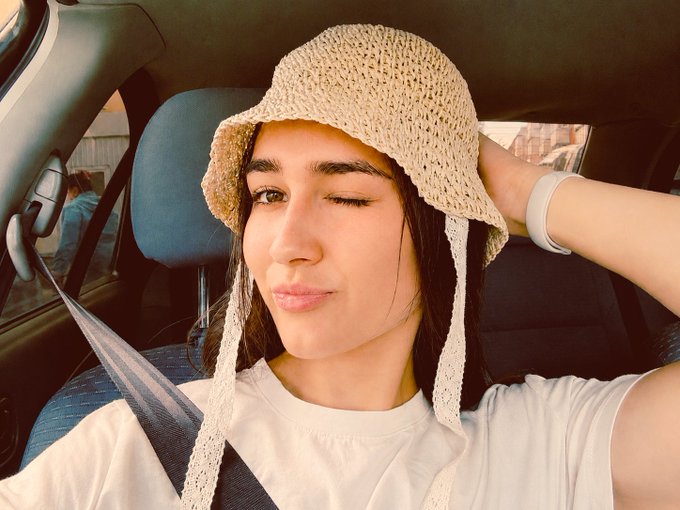 The image features a woman wearing a hat with white lace trim while sitting inside a car, possibly taking a selfie or posing for a picture. The caption of the image reads "If you bought $BTC back in 2021, congratulations bro!! after 5 years you're pretty much where you started + diamond hands + zero gains + legendary patience". This message seems to be related to the woman's hat and her overall appearance, possibly suggesting that she has made a significant financial investment or is celebrating an achievement.