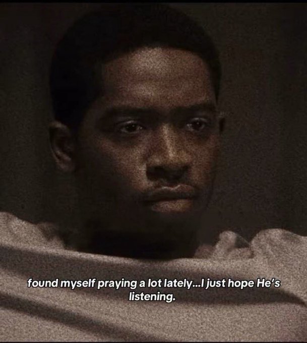 A young man in a dimly lit scene from a film with a contemplative expression, subtitled 'found myself praying a lot lately...I just hope He's listening.'