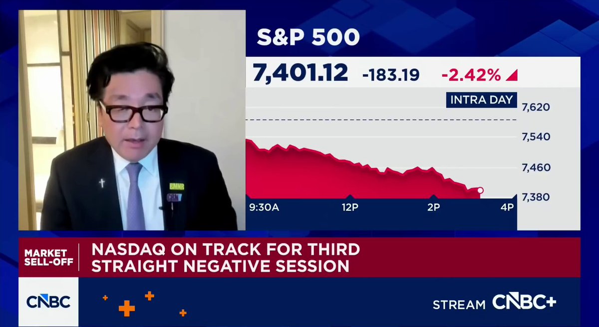 In this image, a man dressed formally in glasses is sitting down with his feet up while talking into a microphone at a news conference. The man appears to be an expert or authority on a specific topic related to finance. On the large screen behind him, there are stock market data and graphs that provide information about the current trends and performance of various stocks. One key fact that stands out is that some of these stocks have experienced a loss in value, indicating that the market conditions might be unfavorable for investors at this time.