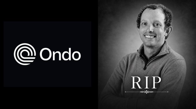 The image features a black and white photo of a man with curly hair wearing a gray sweater, standing against a dark background. The man has his arms crossed over his chest, giving him a relaxed yet thoughtful expression. In front of the man is a logo for the company "Ondo", which is written in white text on a black background. Below this logo, there's a post that reads: "Founder of $ondo Finance Nathan Allman Has Passed Away.. RIP". The image also includes a watermark at the bottom that says "© Ondo".