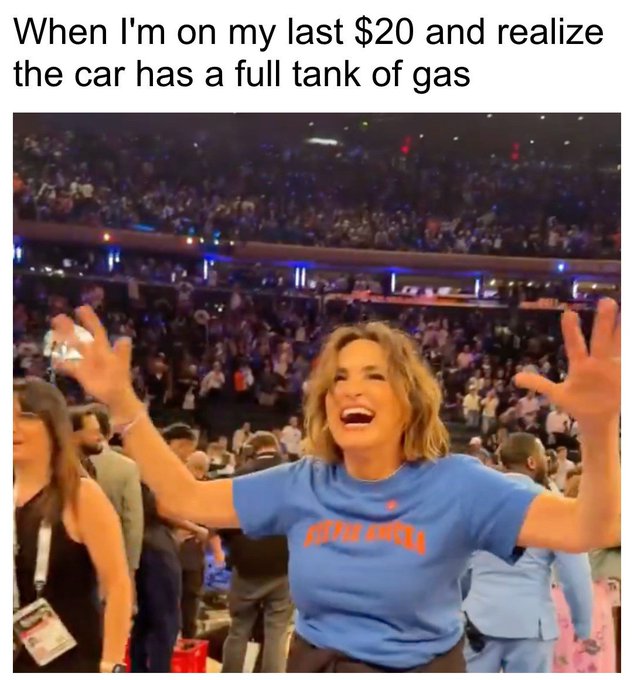 The image shows a woman wearing a blue shirt with an orange graphic, standing next to a group of people at a sports event or concert venue. The crowd appears lively as they enjoy the event together.
