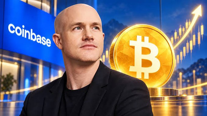 Coinbase CEO Brian Armstrong stands in front of a building labeled "coinbase" with a large golden Bitcoin coin and an upward-trending price chart in the background, visually reinforcing his bullish prediction that Bitcoin has bottomed and will rise over the next two years.
