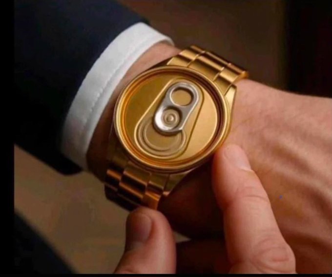 A close-up shot of a person's wrist wearing a large gold-toned watch with its face turned to show the back, revealing the soda can pull-tab design on the case.