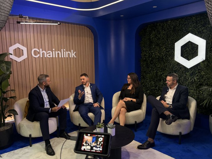 Four business professionals seated in a panel discussion setting branded with the Chainlink logo, appearing to be filmed for a broadcast or podcast.