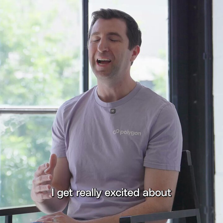 The image shows a man sitting in a chair, wearing a purple t-shirt with "Polygon" written on it. The text in the image reads, "I get really excited about where I was born." This statement seems to be related to the global economy and the idea that one's birthplace should not determine their access to economic opportunities.

The man is sitting near a window, which provides natural light for the scene. There are no other people or objects visible in the image. The focus of the image is on the man wearing the purple t-shirt and his statement about his birthplace.