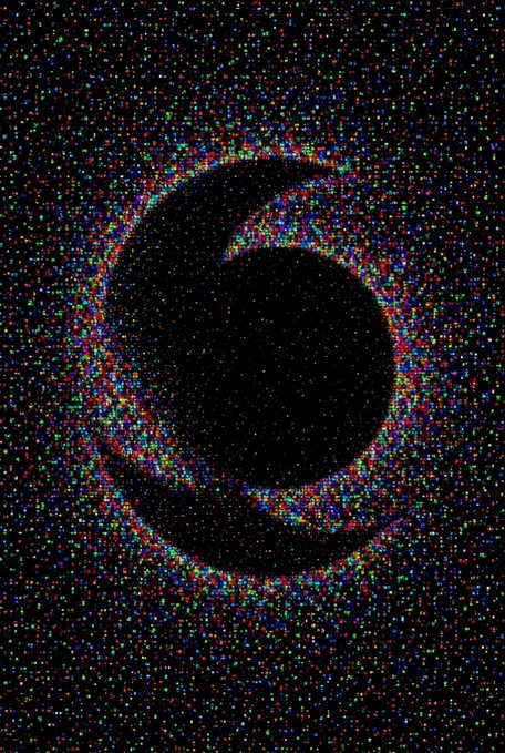 A dark image showing a silhouette of a donut shape against a background of dense, multicolored static or starfield.