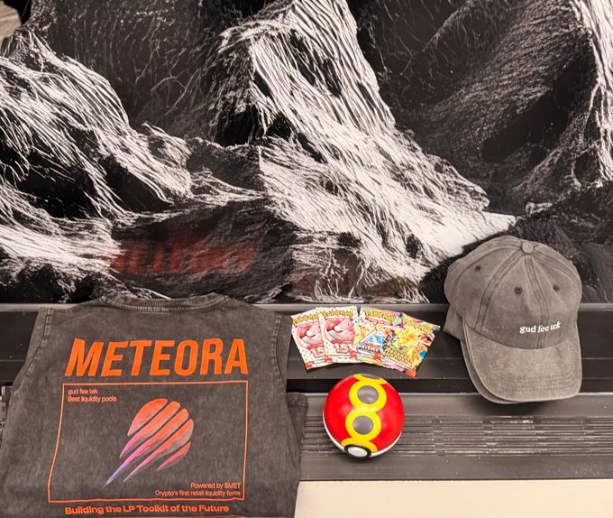 A merchandise display features a 'METEORA' branded gray t-shirt (powered by SUET), a distressed 'guad fine teak' baseball cap, Kinder Surprise eggs, Pokémon card packs, and a red Poké Ball.