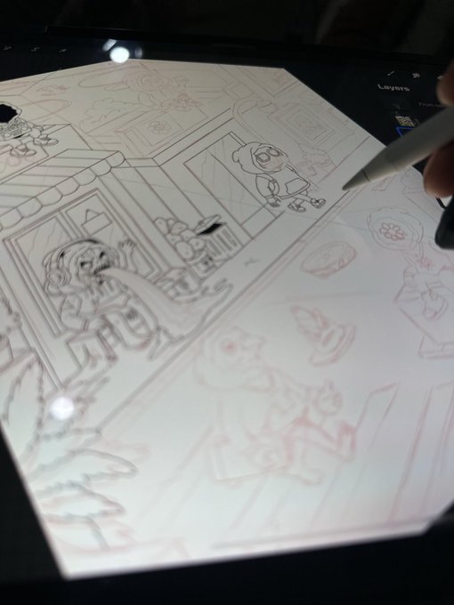 A digital artist's hand using a stylus on a tablet to sketch a cartoon scene featuring characters and architecture in line art.