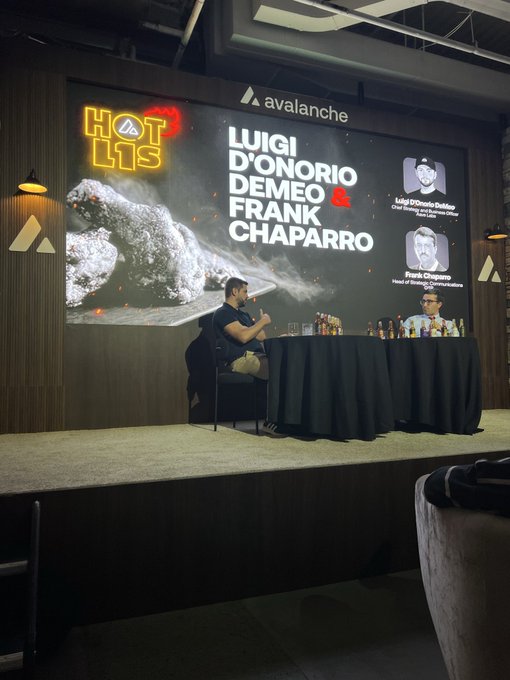 A podcast or interview stage featuring Luigi D'Onorio De Meo and Frank Chaparro from Avalanche Hotlis, displayed on a large screen behind the seated speakers.
