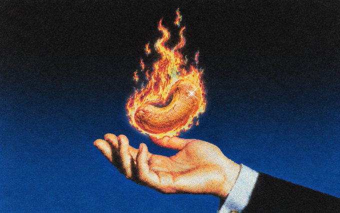 A hand holds a flaming golden cashew nut, symbolically representing a "hot release" that ties into the post announcing new software version releases. The fiery cashew serves as a visual metaphor for fresh, hot-off-the-press updates for CDK and cashu-ts.