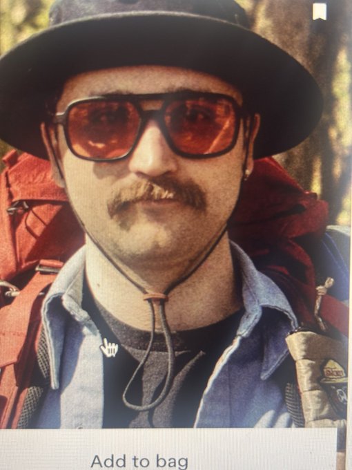 A man wearing a brown hat, sunglasses, and a mustache poses for a photo with a backpack, with an 'Add to bag' button visible at the bottom.