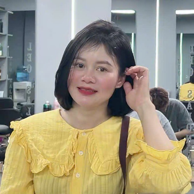 A smiling woman in a yellow ruffled blouse poses for a selfie in what appears to be a hair salon, touching her freshly styled short dark hair. The cheerful portrait pairs well with the post's upbeat "Good morning" greeting, suggesting the new hairstyle marks a fresh, happy start to the day.