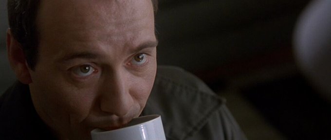 A close-up shot of actor Kevin Spacey from the film "Lost in Space" drinking from a white mug.