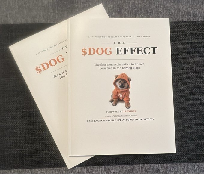 Two copies of 'THE $DOG EFFECT' booklet, subtitled 'A CRYPTAEVOLUTION RESEARCH HANDBOOK 2025 EDITION' and featuring a Shiba Inu in an orange hoodie, with text mentioning Bitcoin and a foreword by Leonidas.